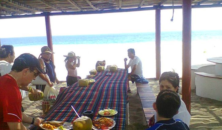 Personas comiendo en laguna de Coyuca